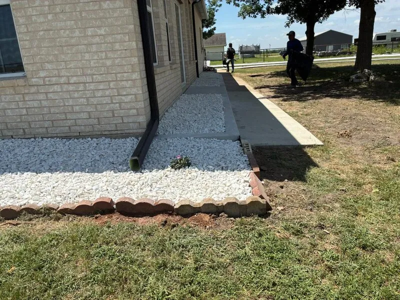 Pasarela de Concreto y Drenaje — Nueva pasarela con borde de grava y ladrillo rojo